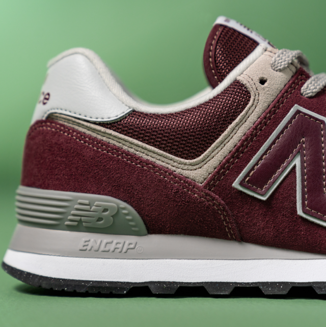 Side view of a burgundy New Balance trainer showing suede and mesh upper with cushioned sole